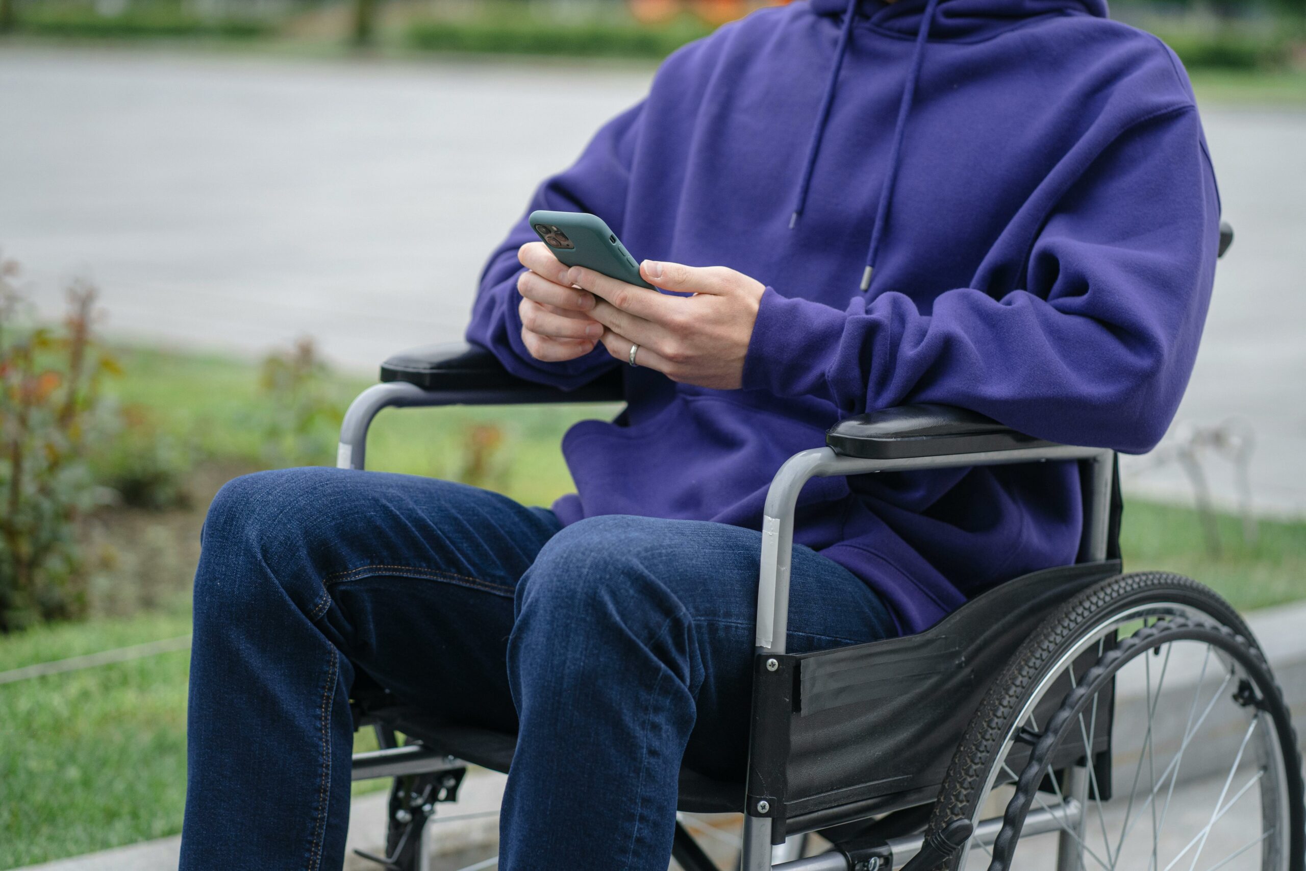 personne en fauteuil roulant tenant un téléphone